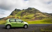 voiture sur route à côté de montagne verte